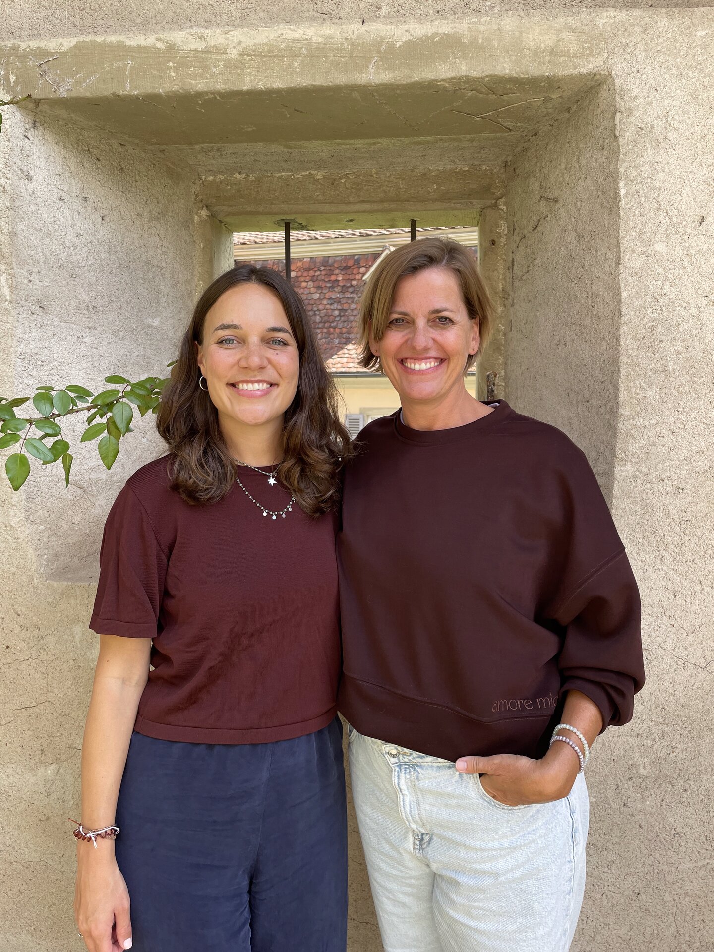 Auf dem Bild ist links Anke Schiek und rechts Stephanie Lewis abgebildet vor einer Burgmauer